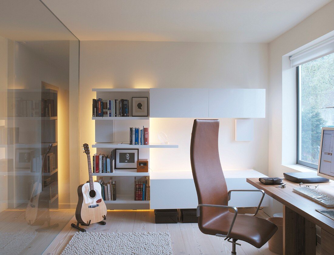 Ein Arbeitszimmer mit einer Gitarre in der Ecke