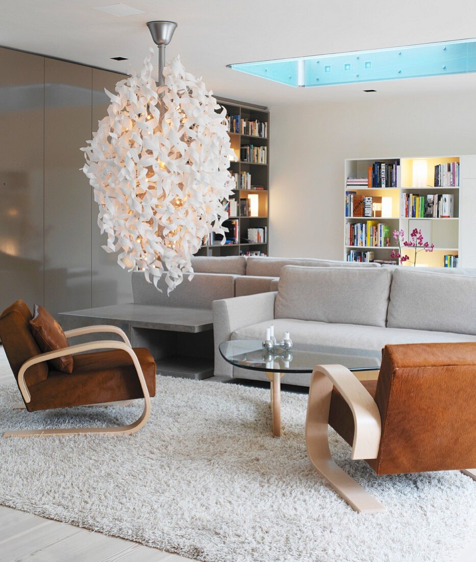 Desingerlampe in einem Wohnzimmer mit grauen und braunen Sitzmöbeln