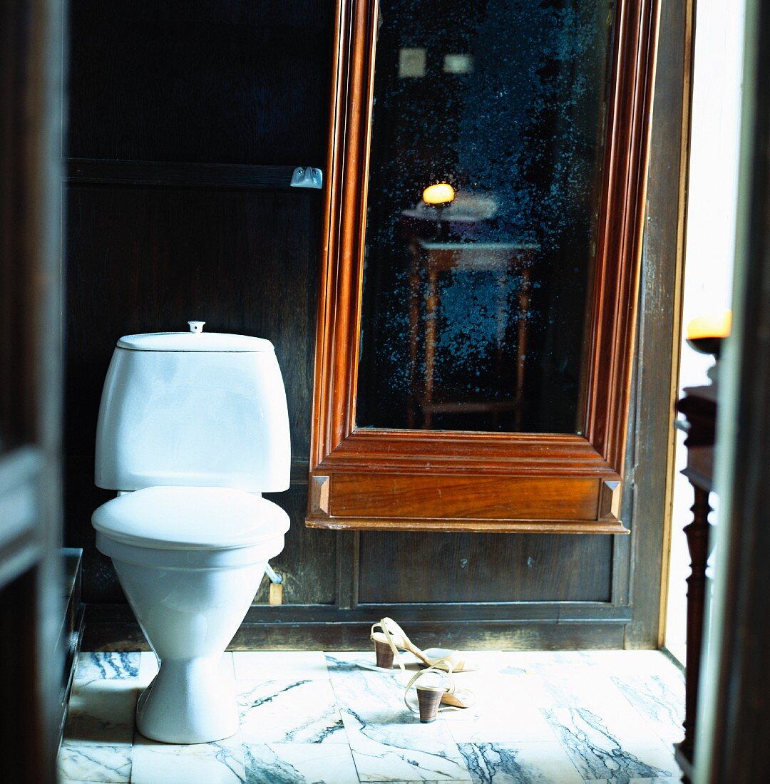 Spiegel mit Holzrahmen neben der Toilette