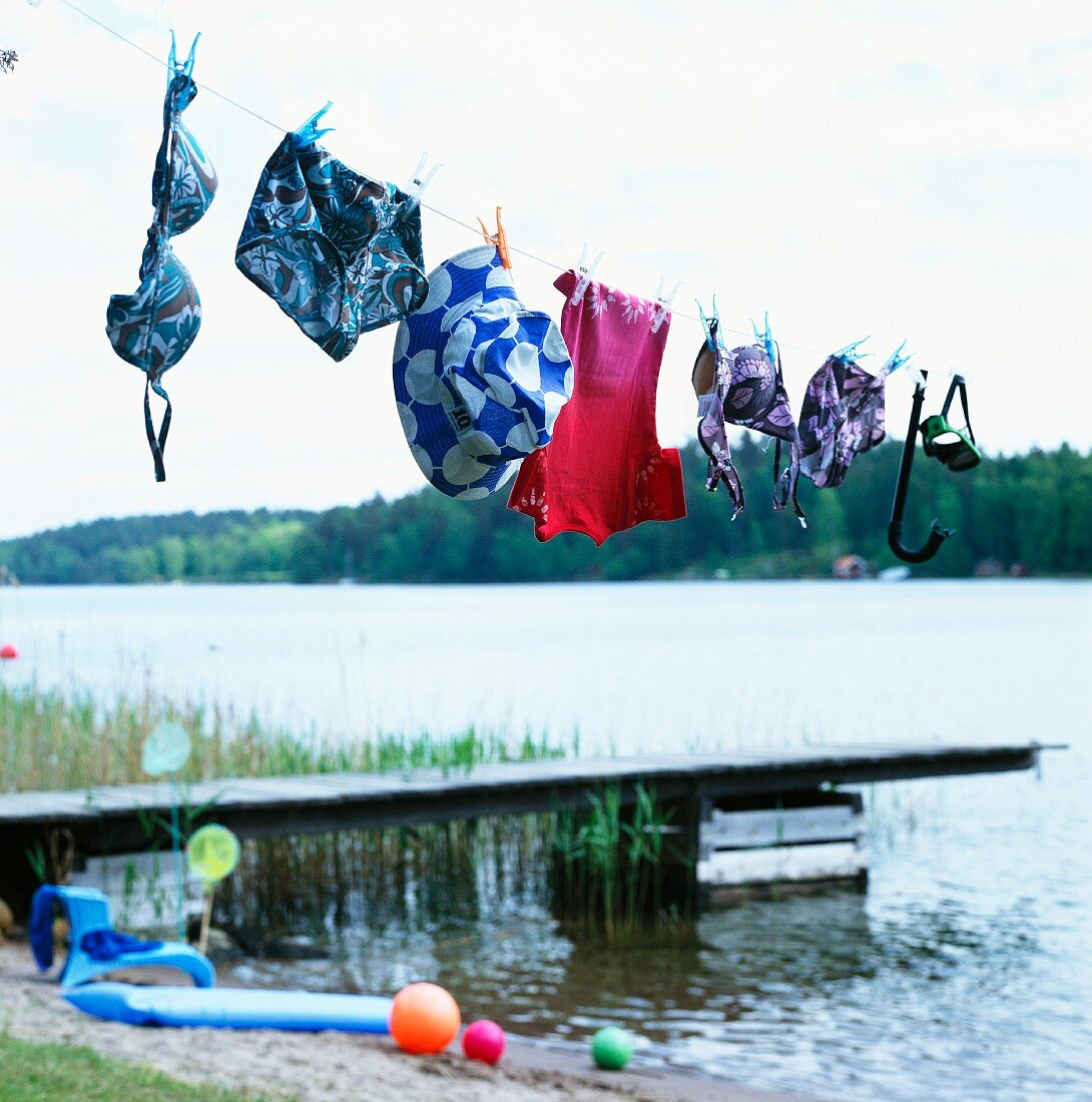 Swimsuits hanging on washing line in front of jetty