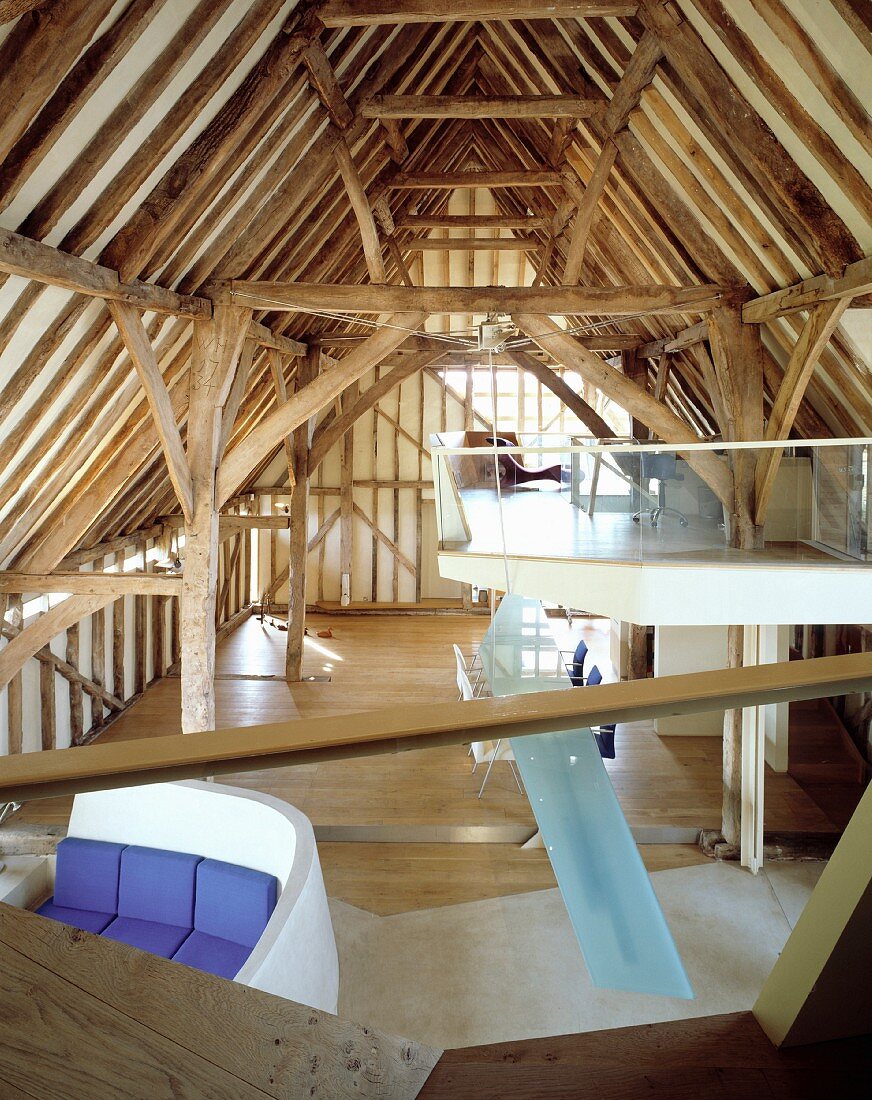 Irregular, modern installations in historic roof structure - suspended gallery level with transparent glass balustrade