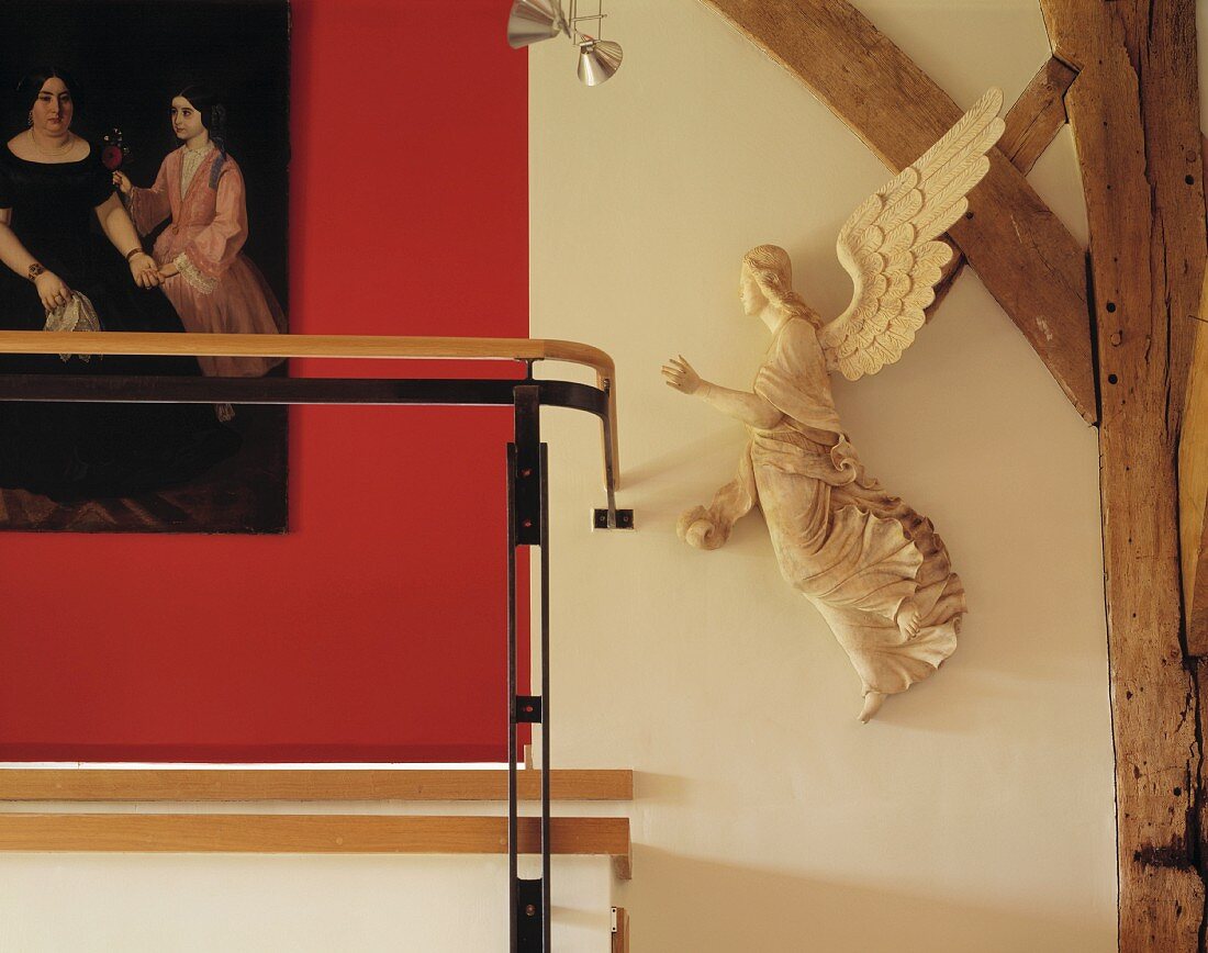 Angel next to half-timbered beams and detail of historic painting against red wall