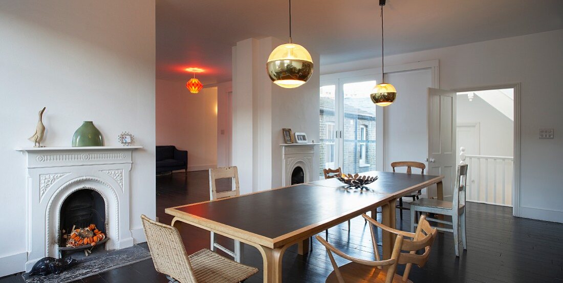 Altbauflair in Londoner Dachwohnung mit langem modernem Esstisch, Stühle-Sammlung und Retrolampen