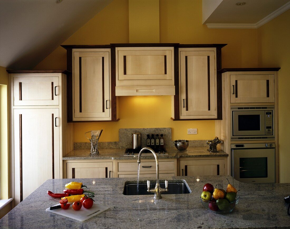 Decorative cupboard doors and granite work surfaces in modern fitted kitchen
