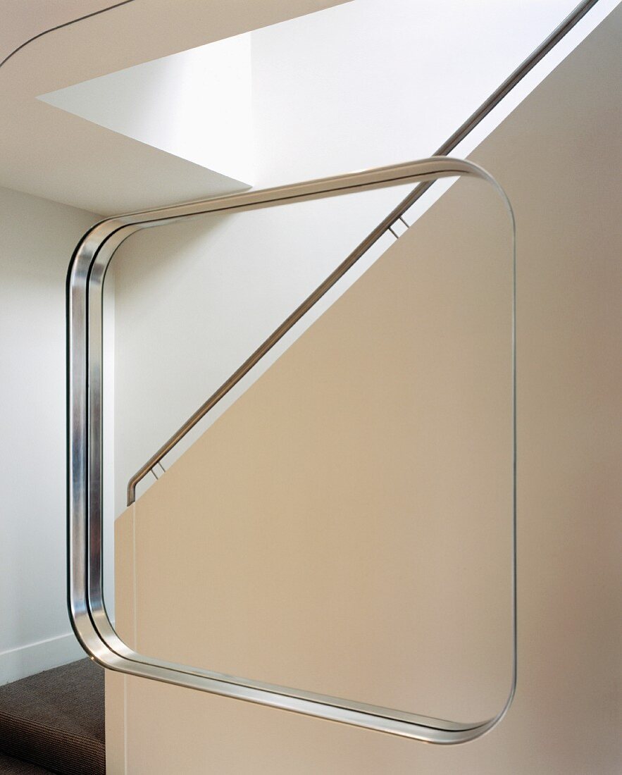 Mirror image of a purist staircase with stainless steel handrail