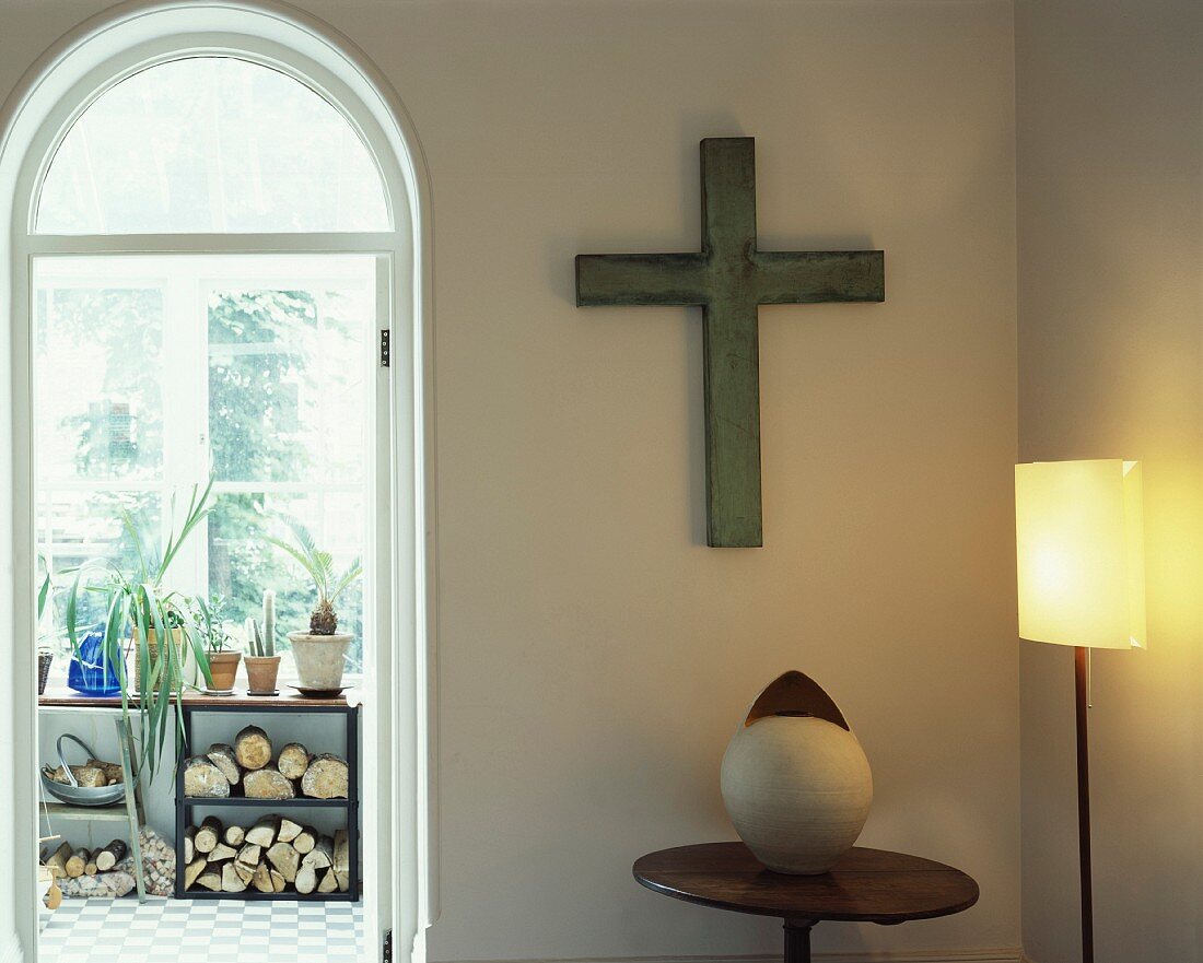 Kreuz an der Wand in Zimmerecke und Rundbogen- Durchgang mit Blick in Loggia