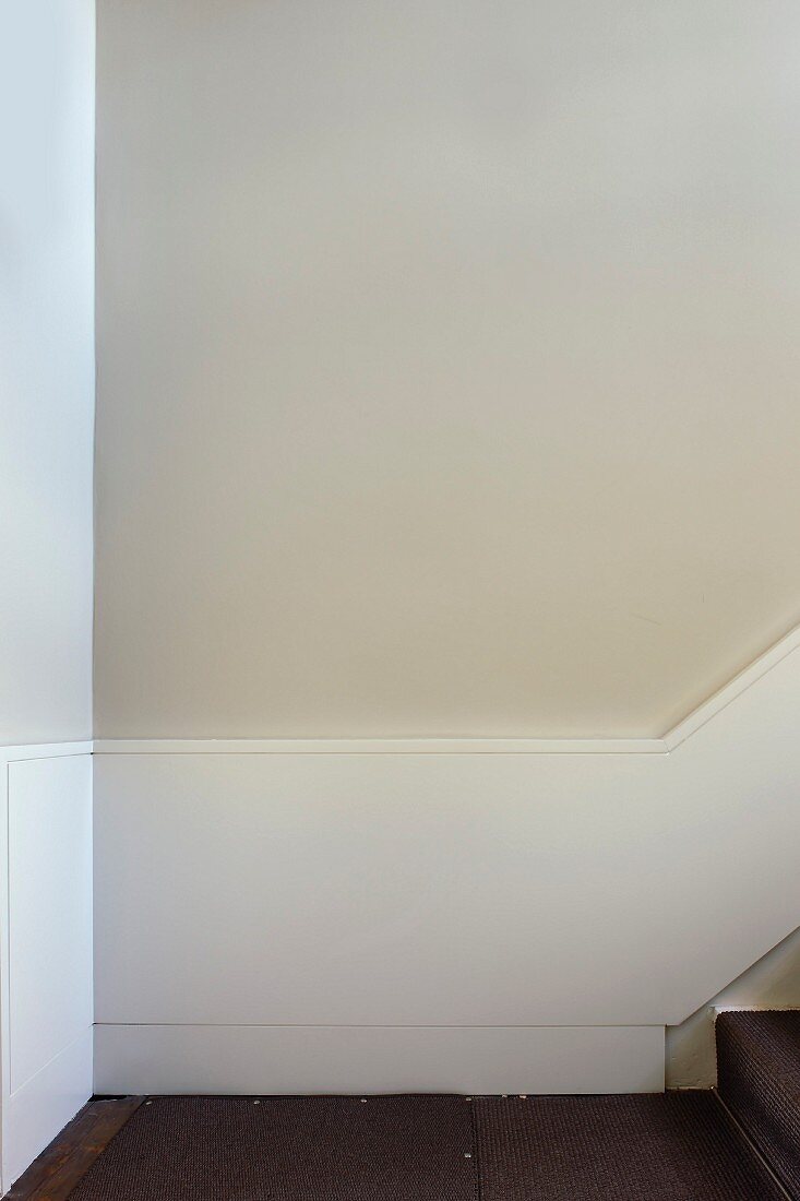 Half-height, white-painted wood panelling on walls of stairwell