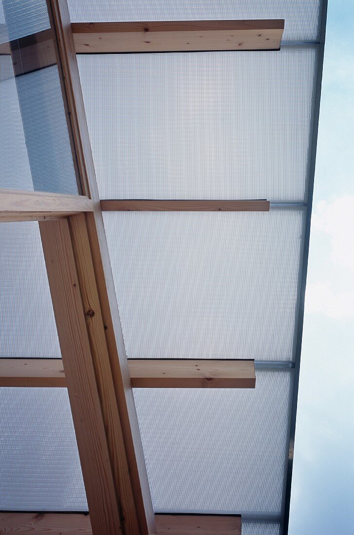 Detail of roof overhang - roof of plastic panels on wood beam frame