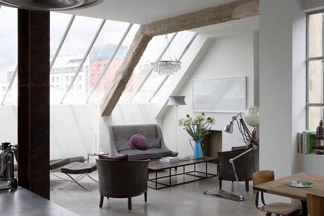Offener Wohnraum mit Möbeln im Stilmix unter verglaster Dachschräge