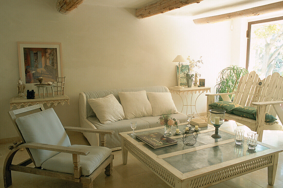 Bright living room with light-colored furniture and rustic wooden beams