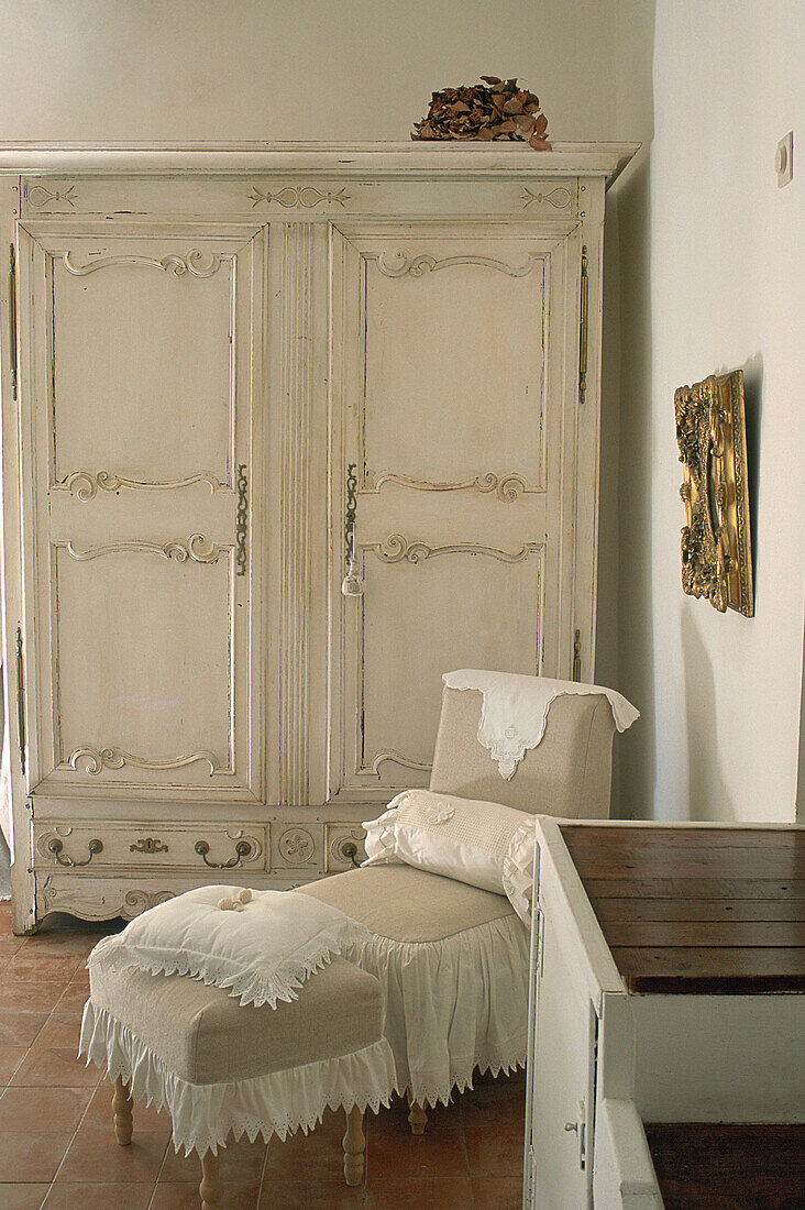White vintage wardrobe and chaise longue in shabby chic style
