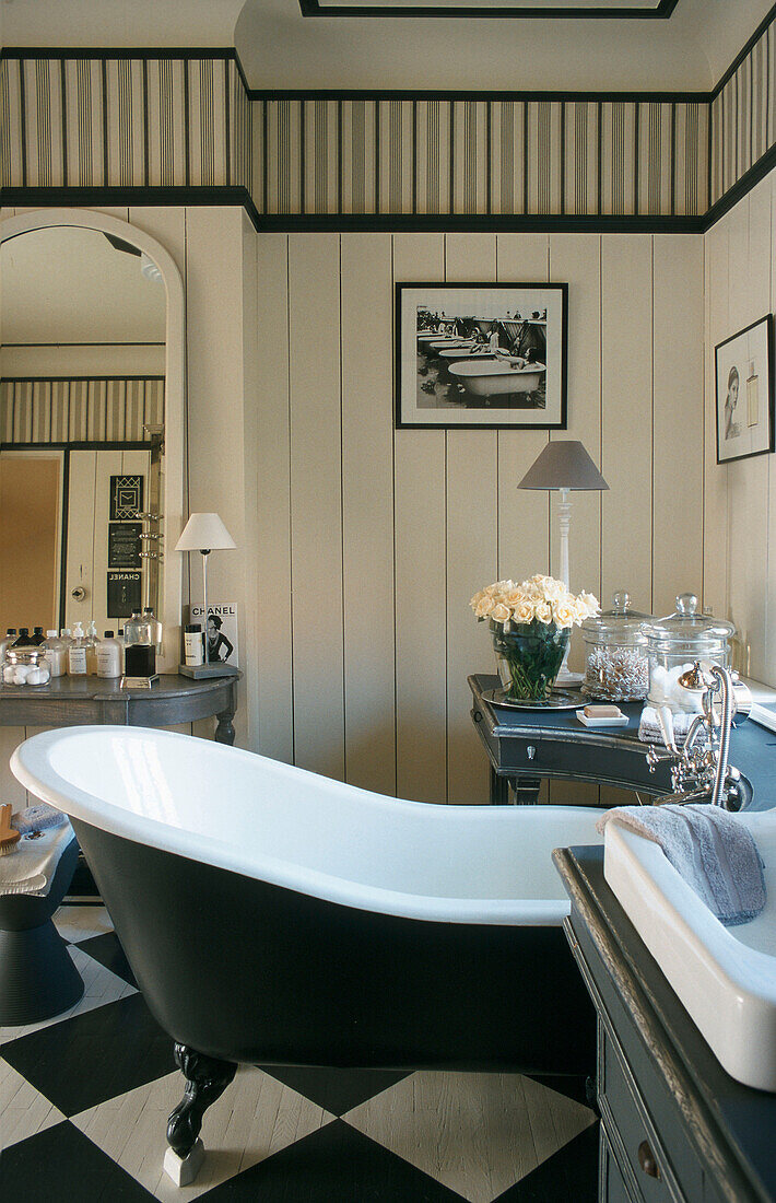 Free-standing bathtub in bathroom with black and white floor
