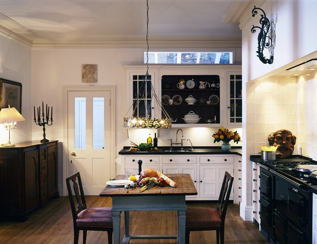 Traditional country kitchen with rustic kitchen table and antique chairs