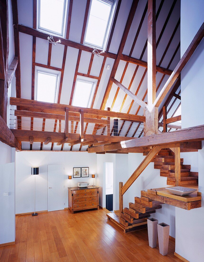 Ausgebautes nach oben offenes Dachgeschoss mit rustikaler Treppe