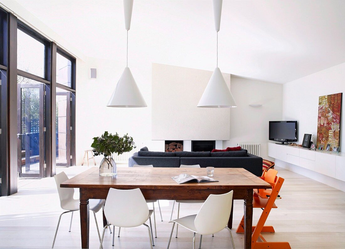 Essplatz mit rustikalem Holztisch in modernem Wohnraum mit Kamin