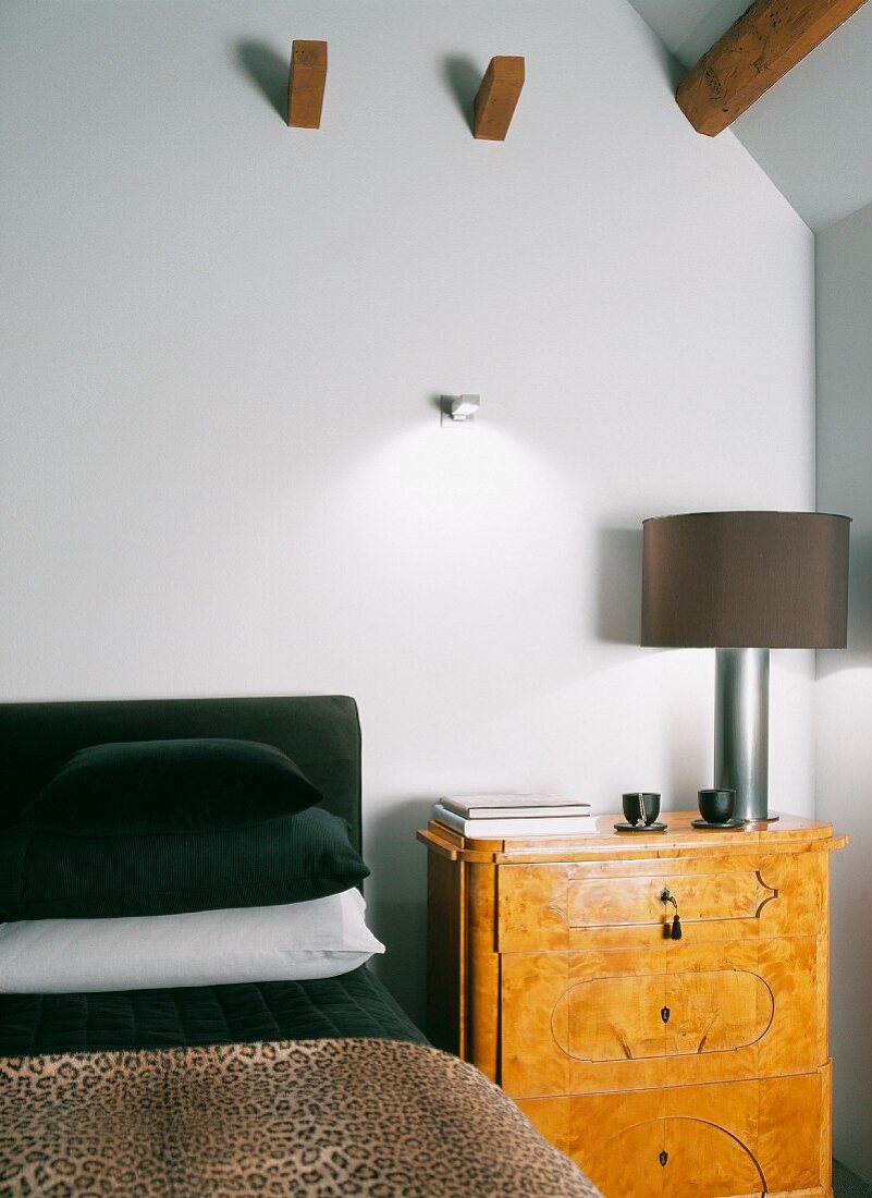 Nachttischkonsole im Biedermeierstil mit moderner Nachttischlampe neben Bett