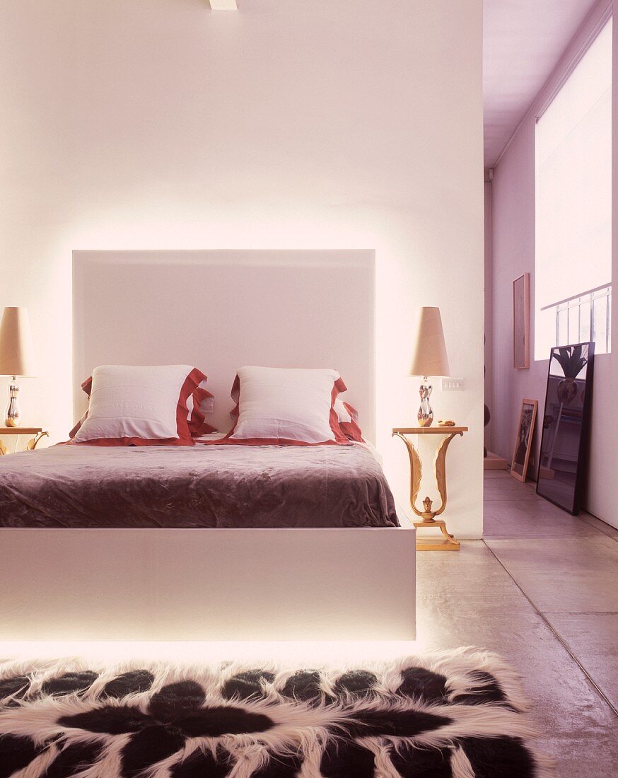 Loft mit offenem Schlafbereich und modernem Bett mit indirekter Beleuchtung