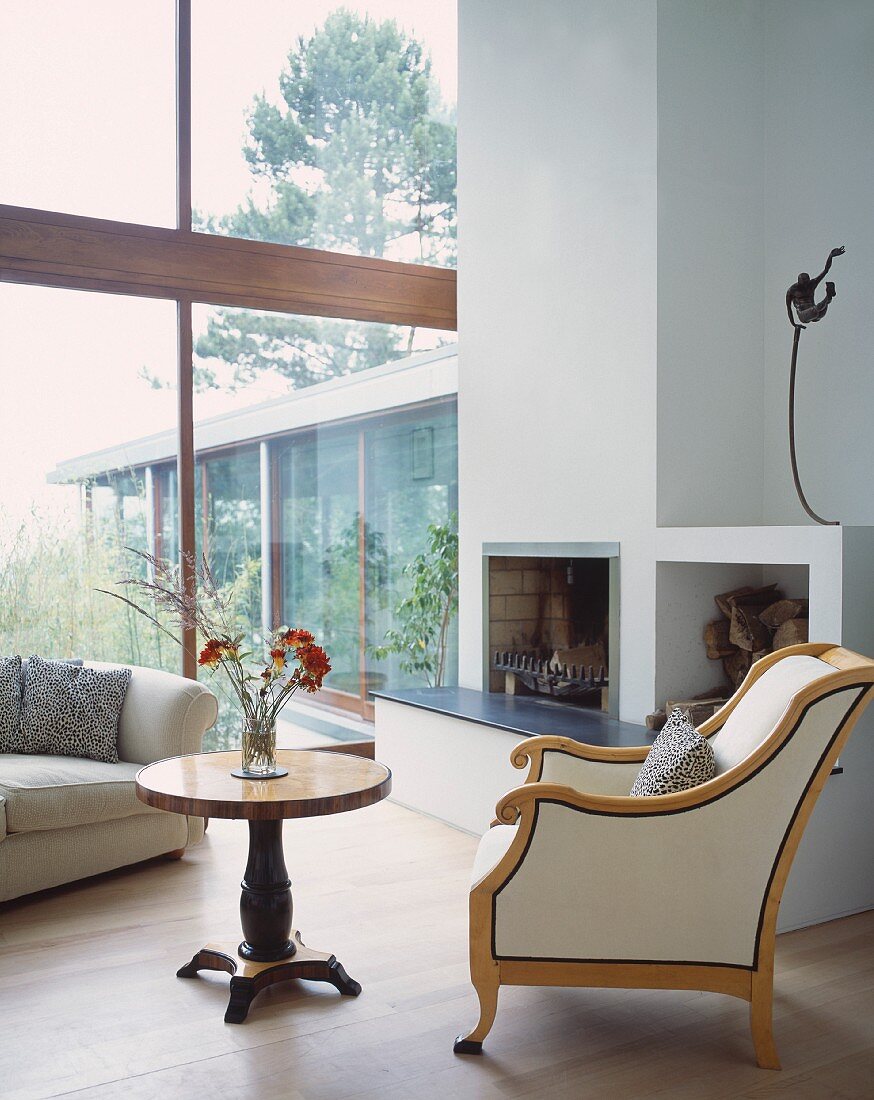 Retro armchair and side table next to open fireplace in contemporary house
