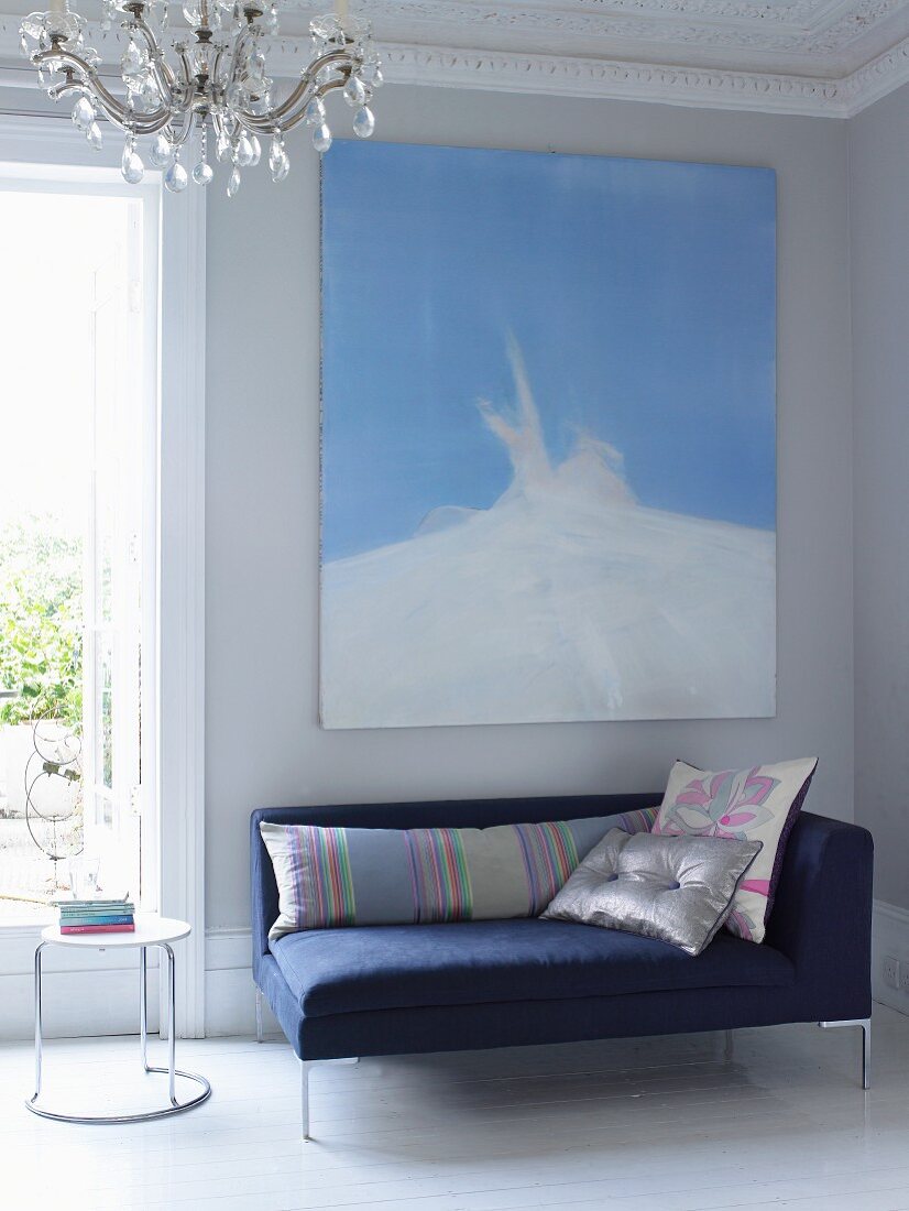 Moderne blaue Recamiere in Wohnraum mit Wandgemälde