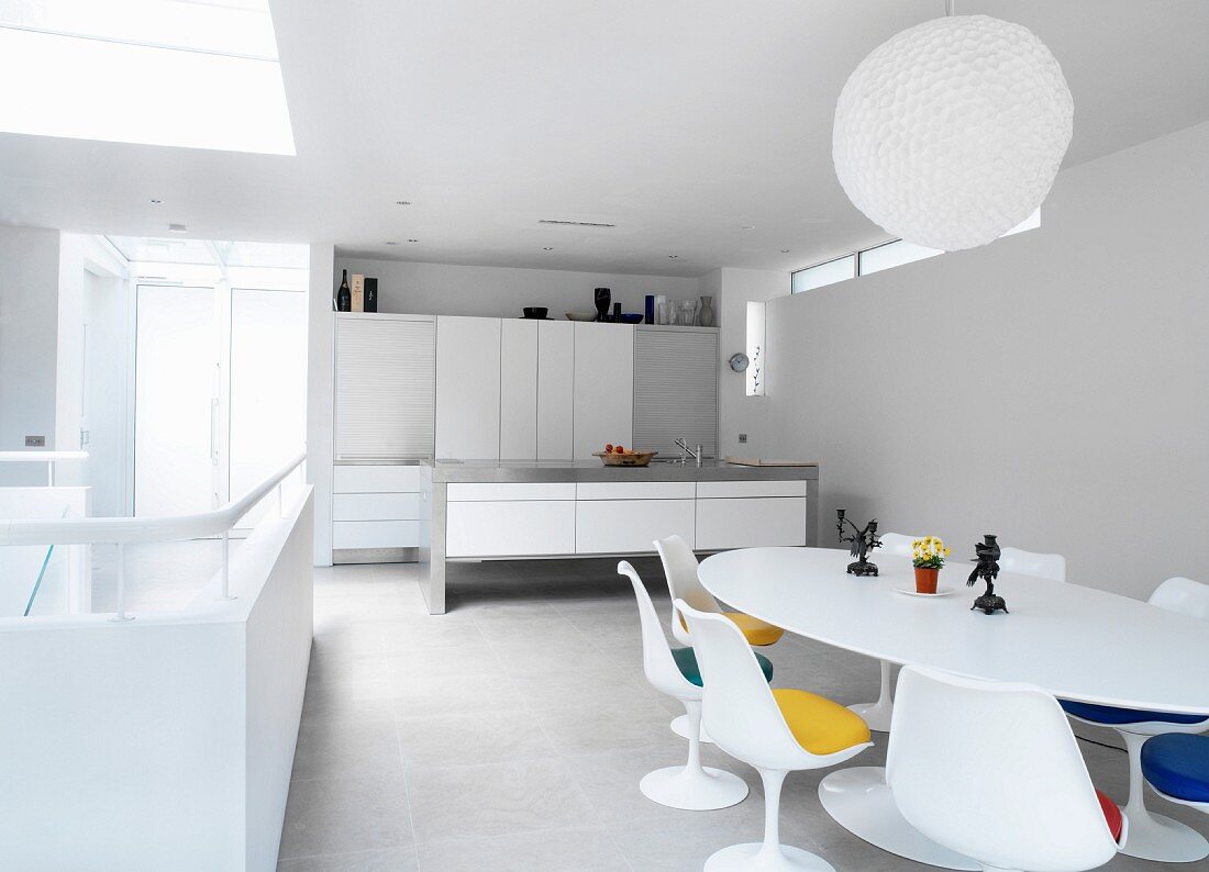 Offener Wohnraum mit minimalistischer Küche und weißem Essplatz im Designer-Retrostil