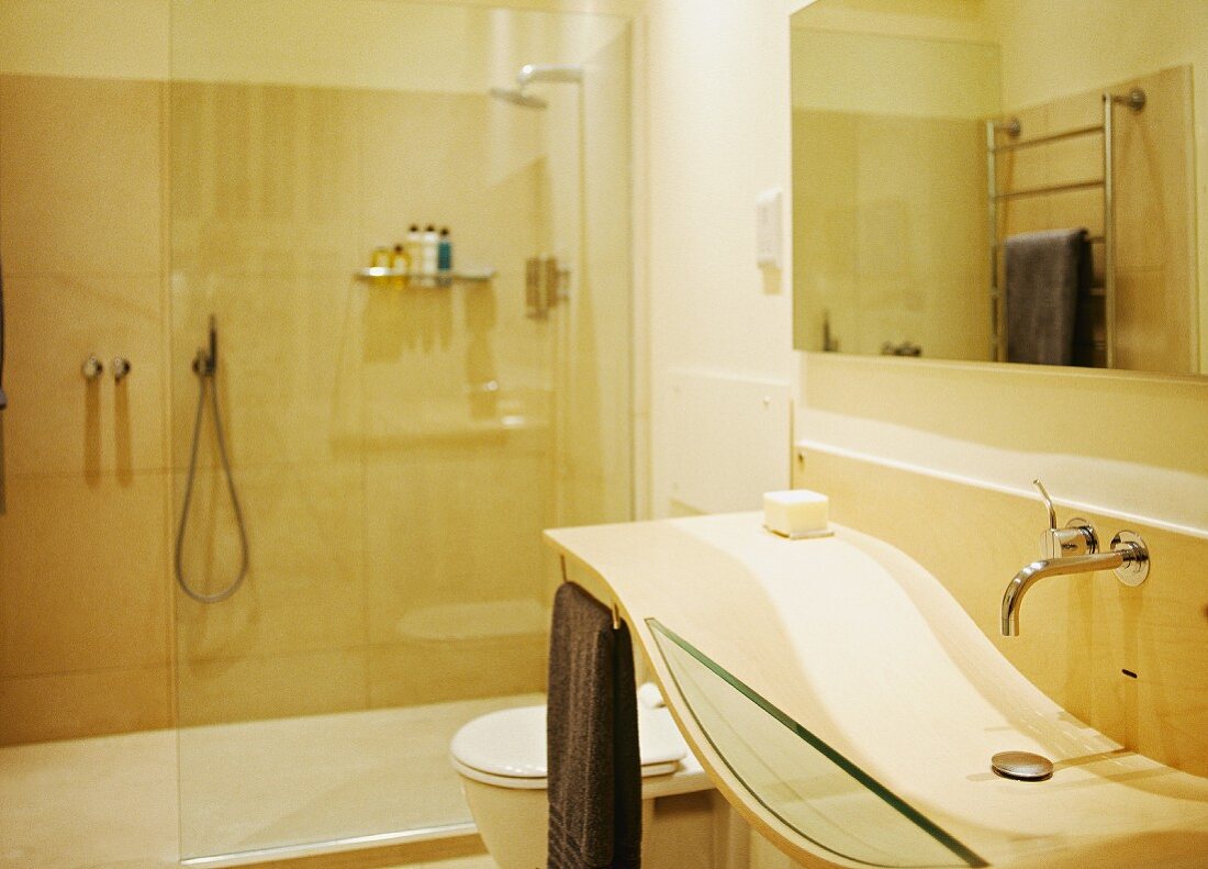 Wellenförmiges Designer-Waschbecken im modernen, cremefarbenen Bad