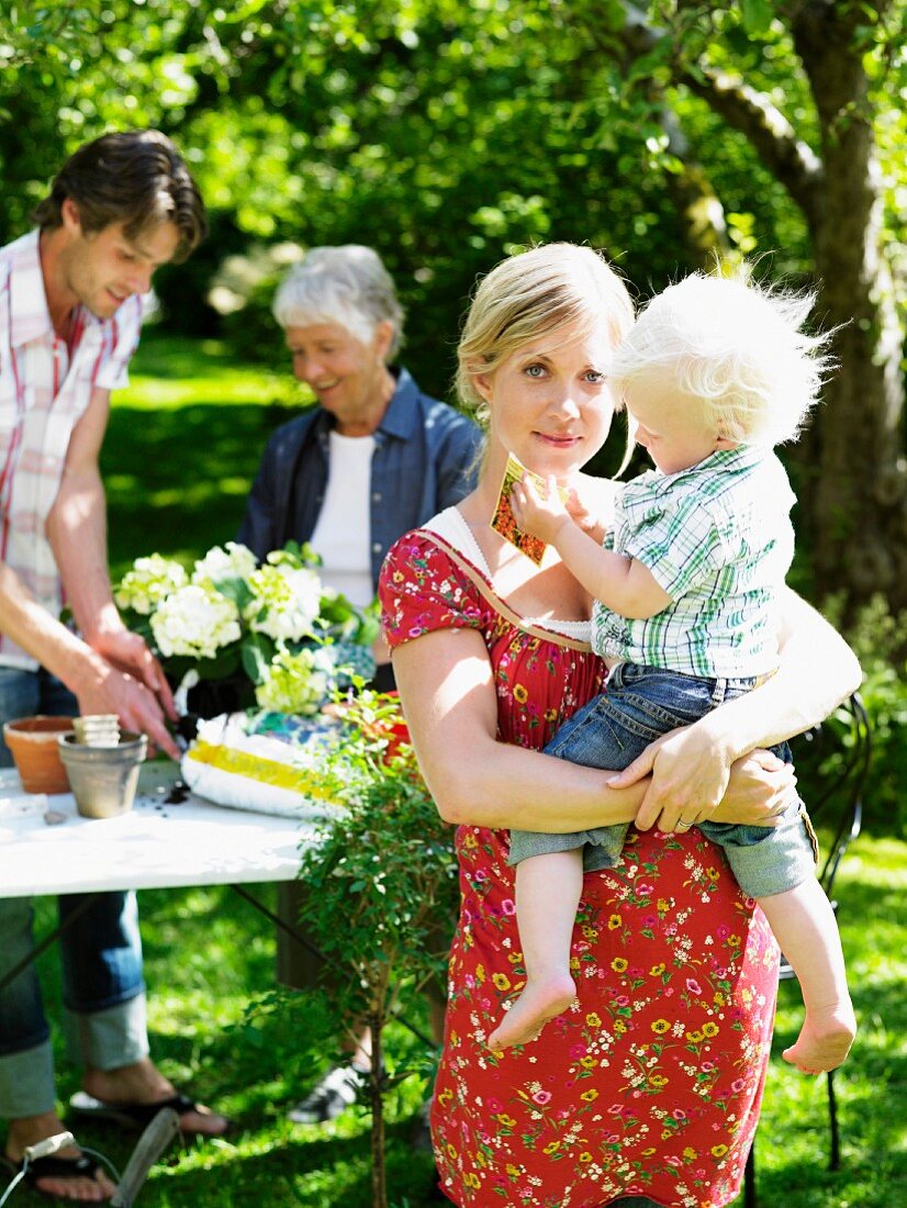 Young family and grandmother in garden