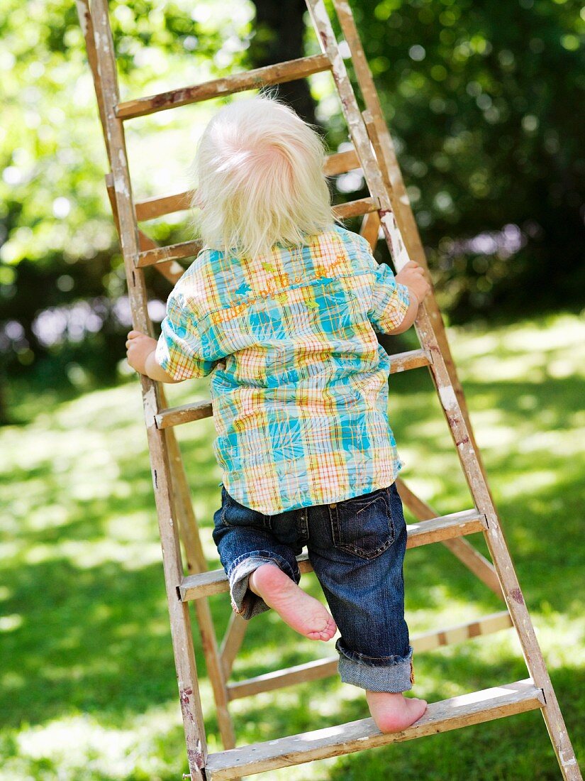 Kleines Kind steigt eine Leiter hoch