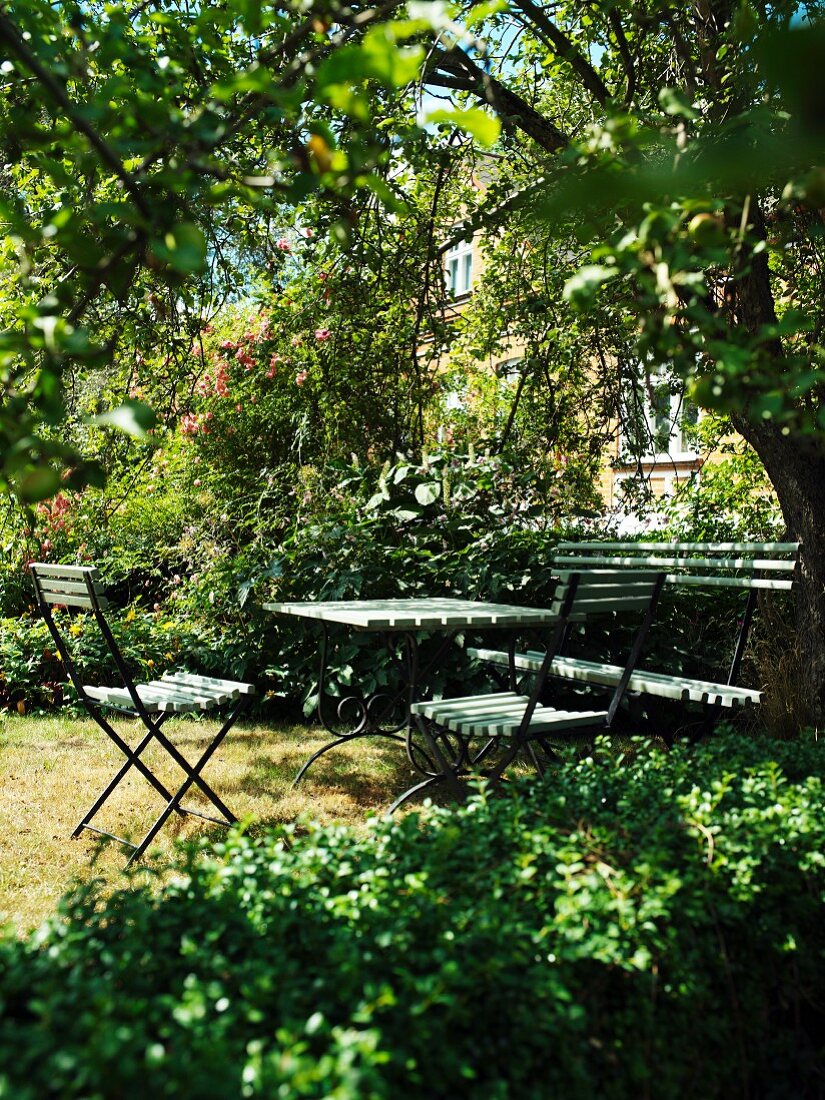 Halbschattiger Gartenplatz mit Tisch und Sitzgarnitur