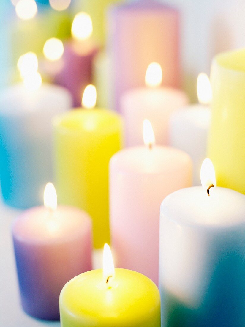 Verschiedenfarbige Kerzen mit brennenden Lichtern