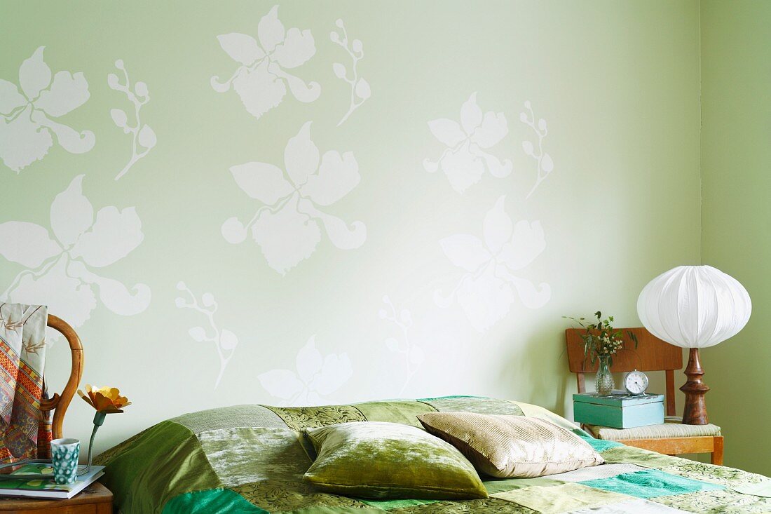 Bed with a green bedspread and pillows in a bedroom