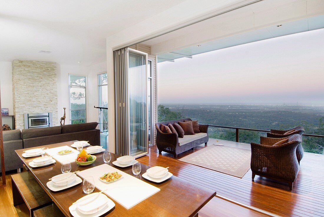 Panoramic view of landscape across balcony from open-plan dining room