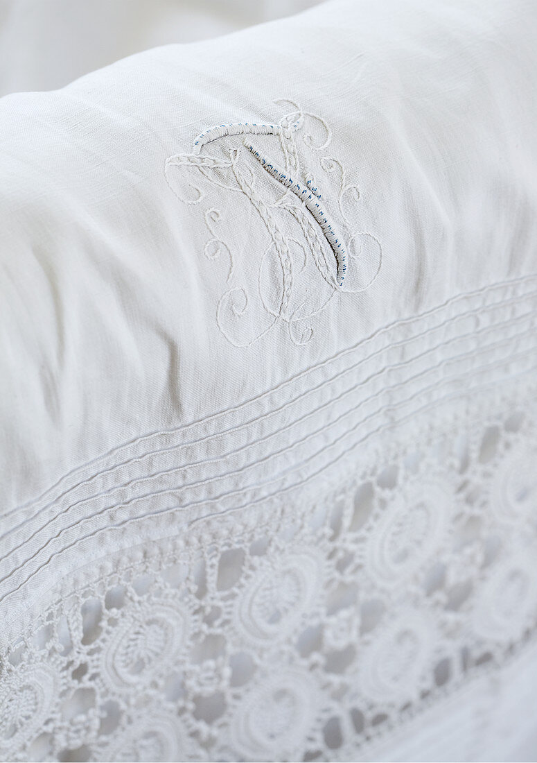 White fabric with lace edging and embroidered monogram