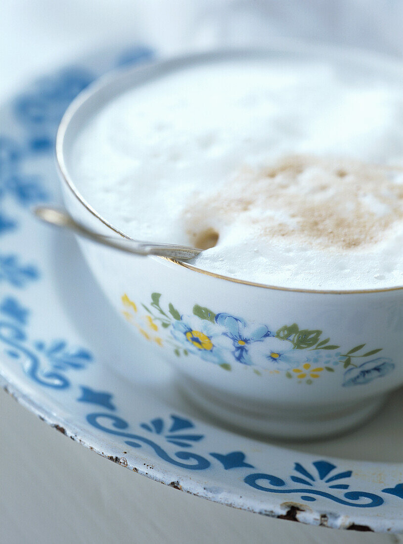 Cappuccino in einer Vintage-Tasse mit Blumenmuster