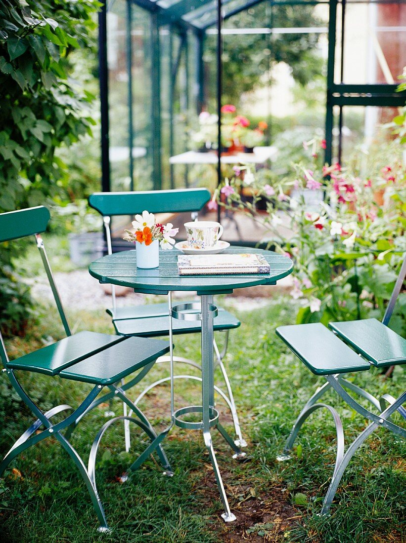 Modern garden table with chairs in front of a conservatory