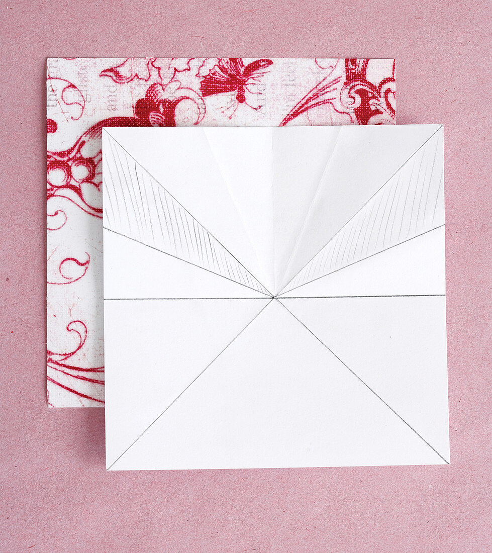 Fotostrecke mit Faltanweisungen für eine Papierblüte aus rot-weiss gemustertem Origami-Papier