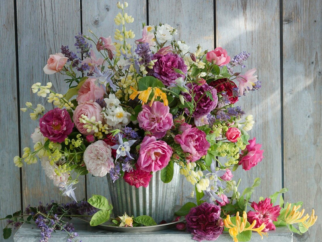 Colourful bouquet in glass vase against wooden wall