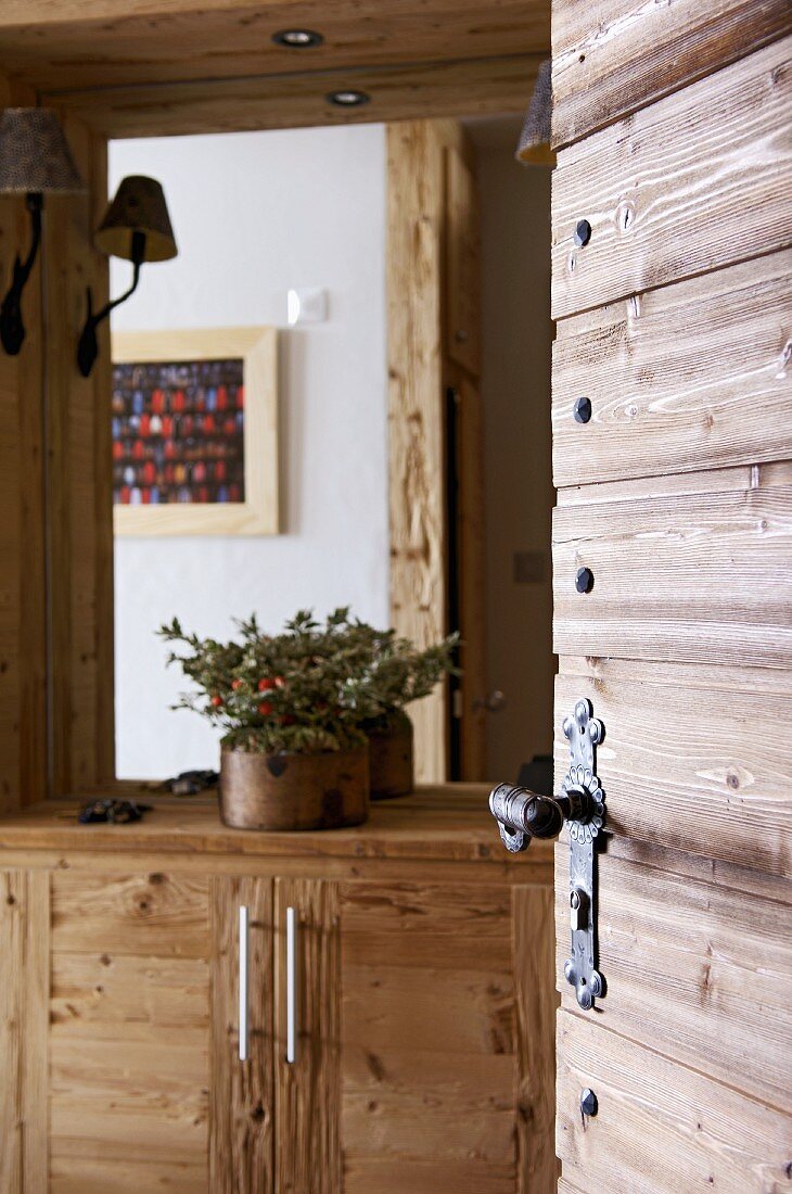 View of rustic, wooden sideboard through open interior door