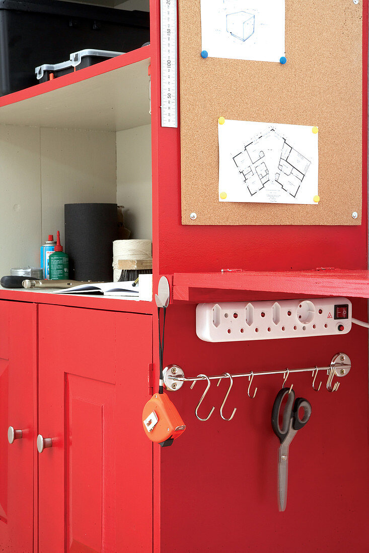 Rotes Werkzeugregal mit Pinnwand, angebauter Arbeitsplatte, Steckerleiste und Hakenstange