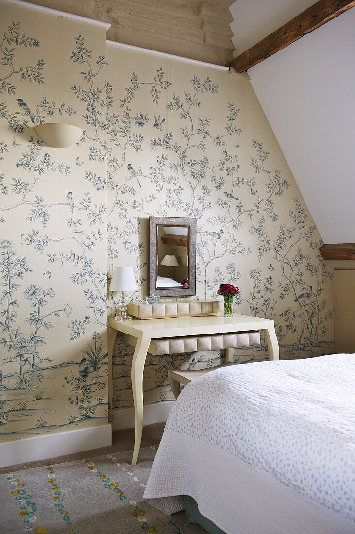 Postmodern table against patterned wallpaper in attic bedroom
