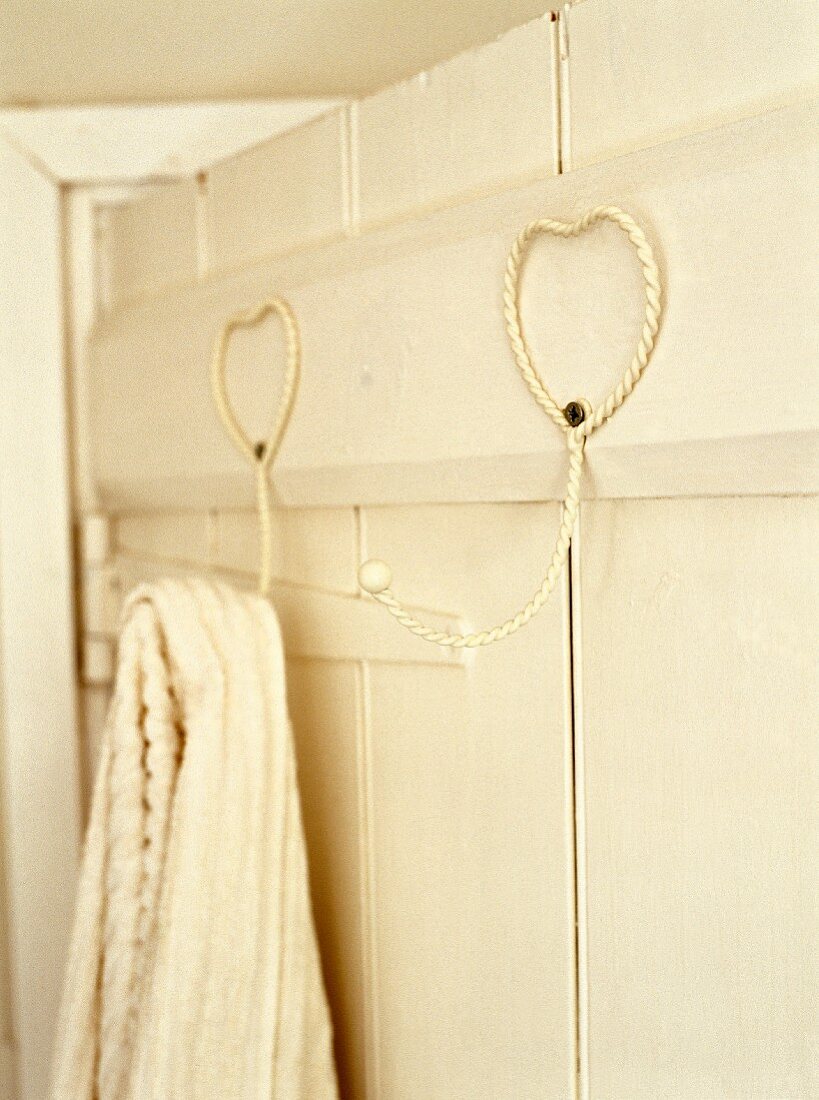 Heart-shaped, metal hooks on wooden wall