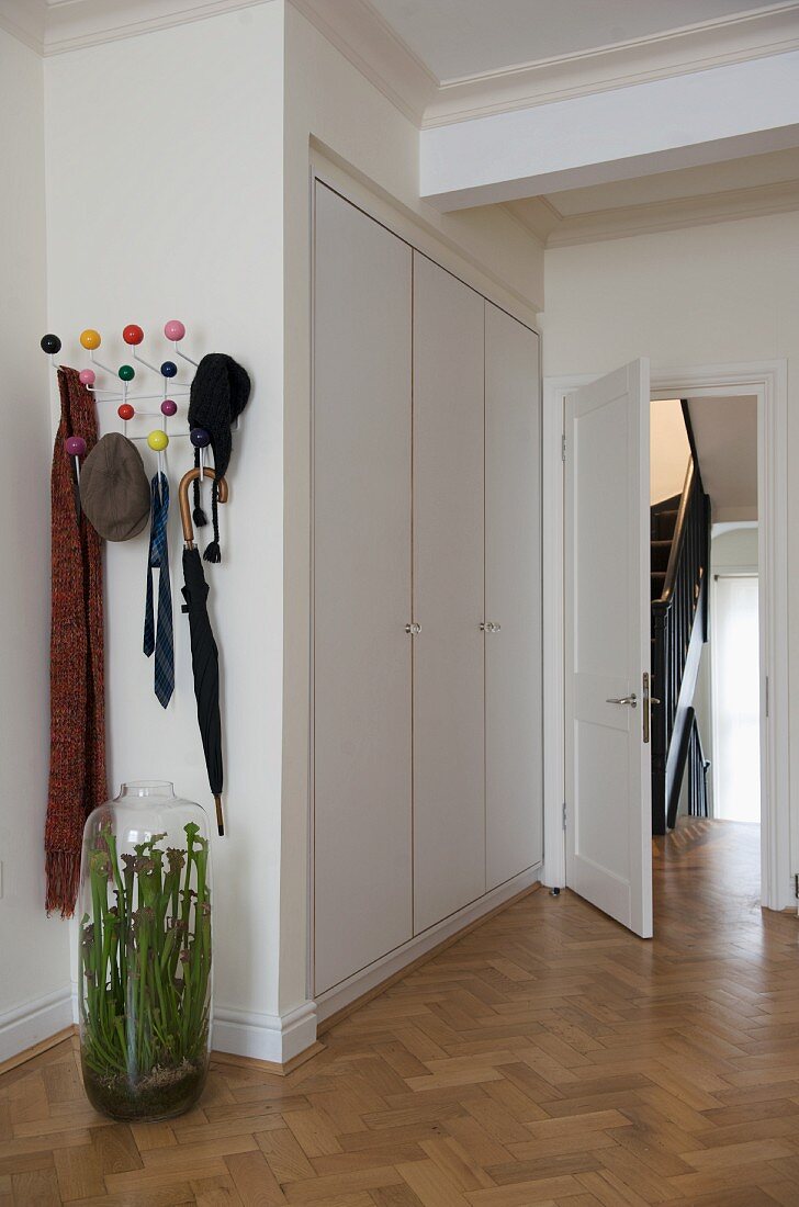 Glasvase vor Garderobe und weisser Einbauschrank im Vorraum
