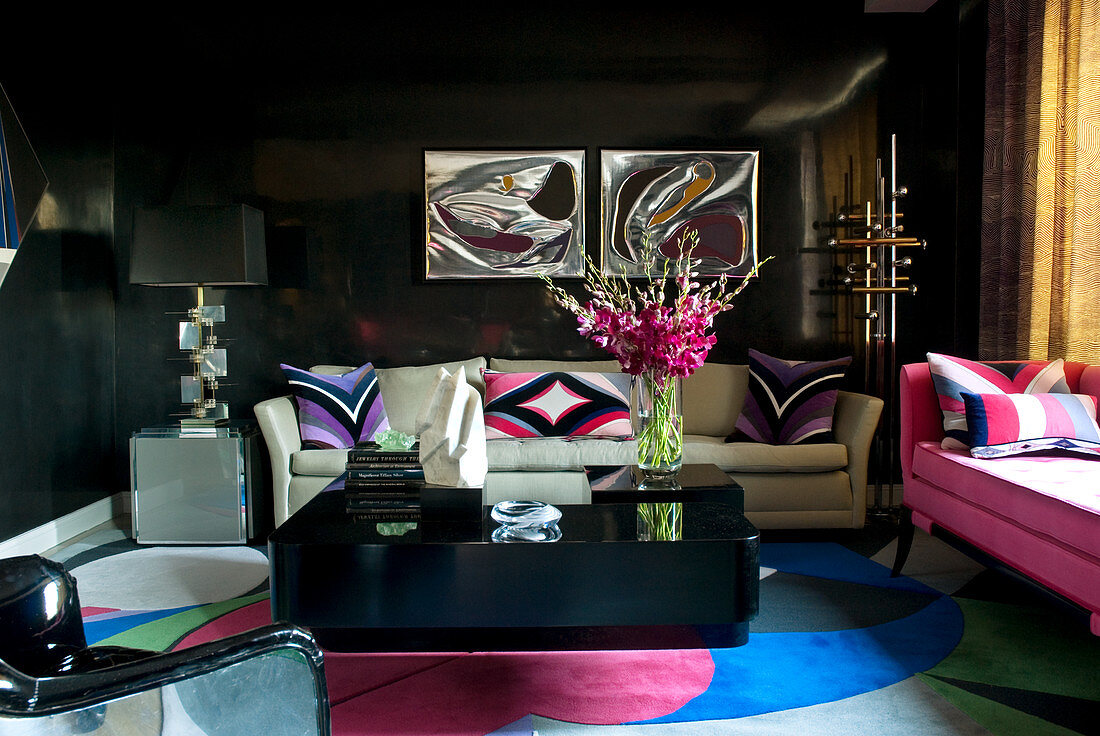 Black Venetian plaster walls, colourful silk carpet, sofas and black coffee table in elegant living room
