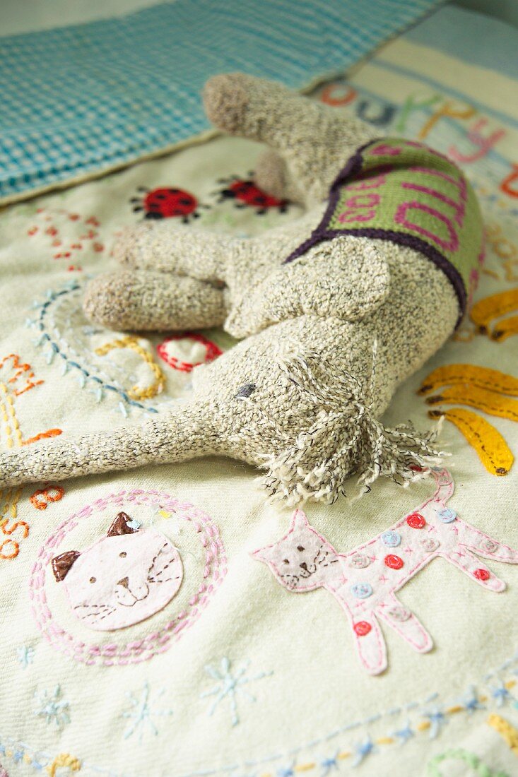 Soft toy on embroidered child's bedspread