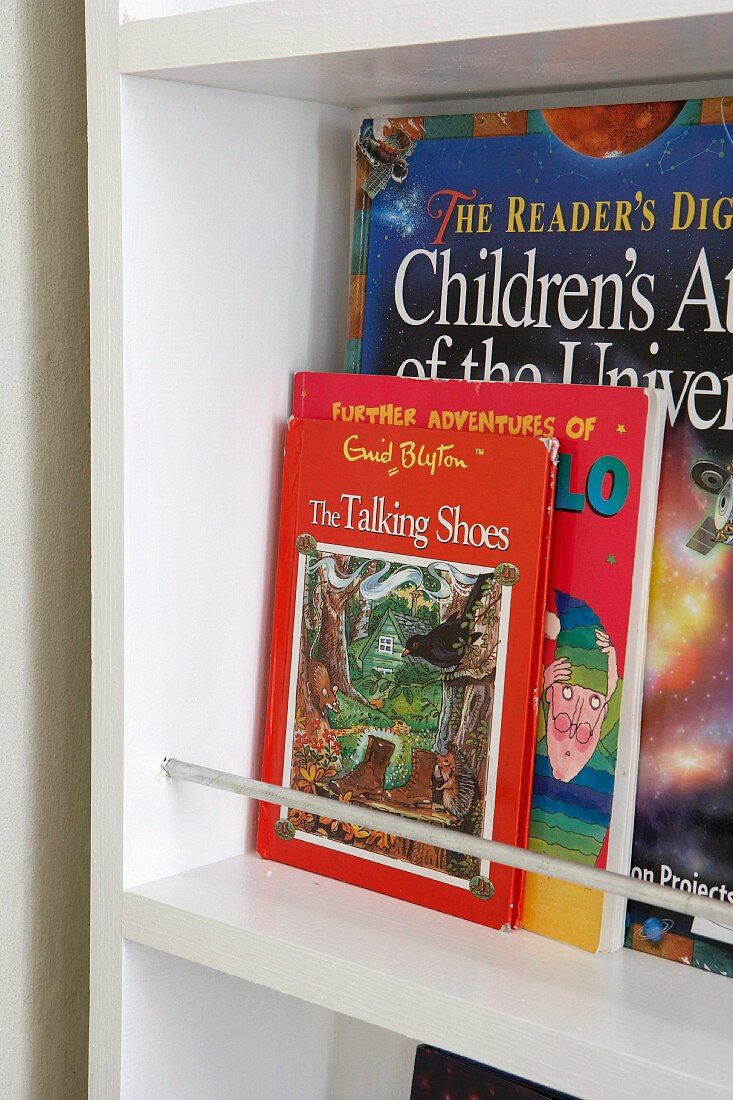 An English children's book with the cover facing outward in a white shelf