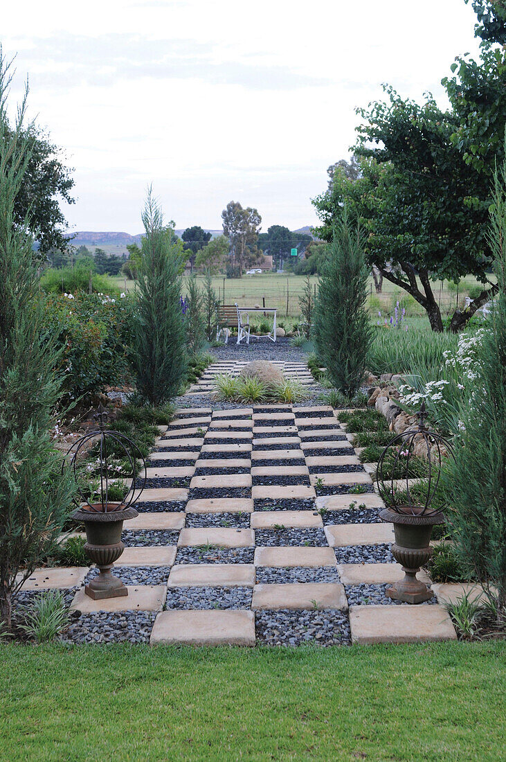 Ein breiter Gartenweg mit Pflastersteinen und Kies