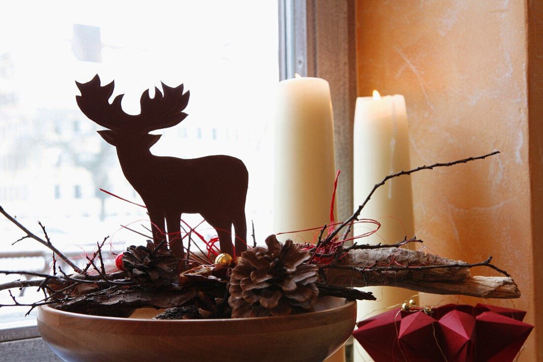 Festive deer figurine on fir cones and wood