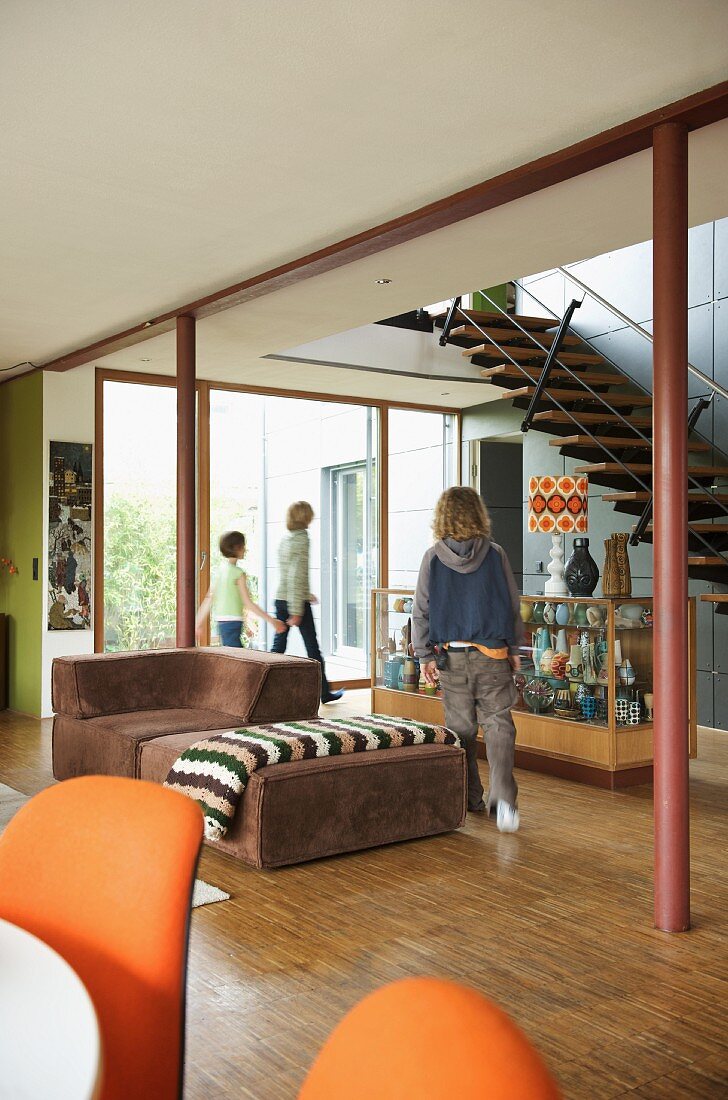 Children in open-plan room with 70s-style furniture