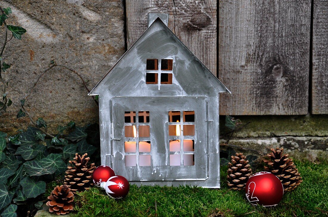Weihnachtliche Gartendeko: Zinkhäuschen mit Kerzen auf Moos