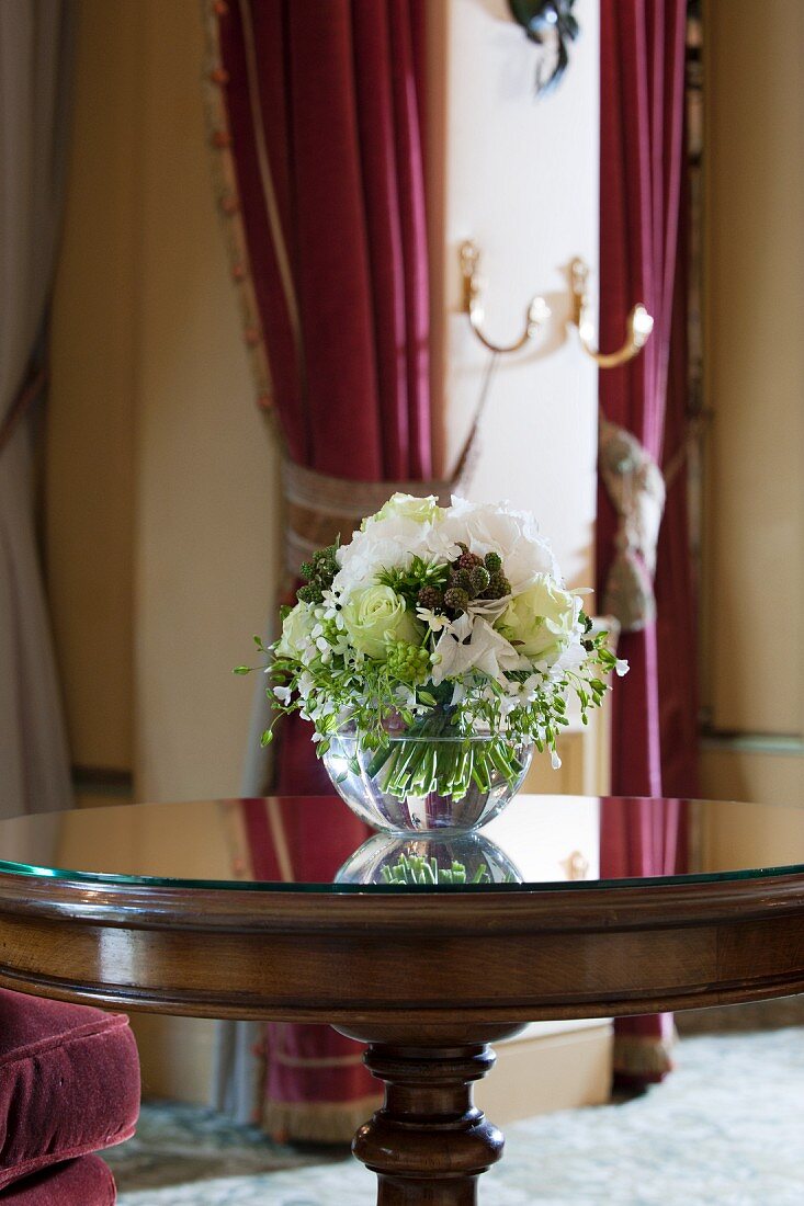 Blumenarrangement auf einem runden Tisch in elegantem Hotel