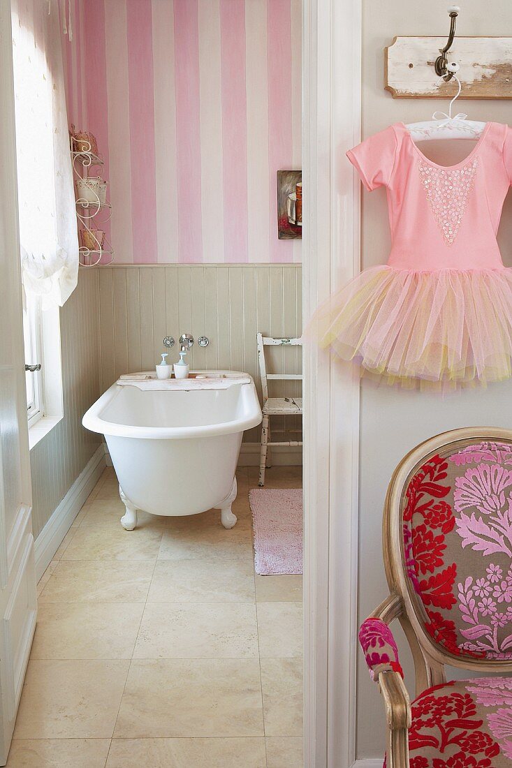 Badezimmer mit freistehender Badewanne und rosa-weiss gestreifter Tapete